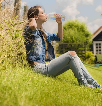 Vrouw met glas water in tuin