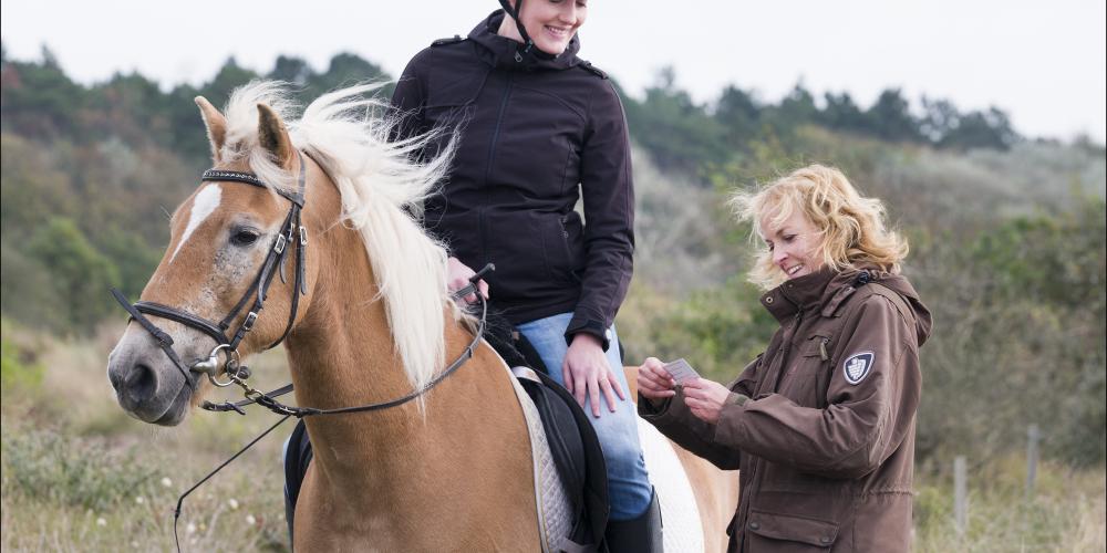 Boswachter controleert ruiter te paard op duinkaart
